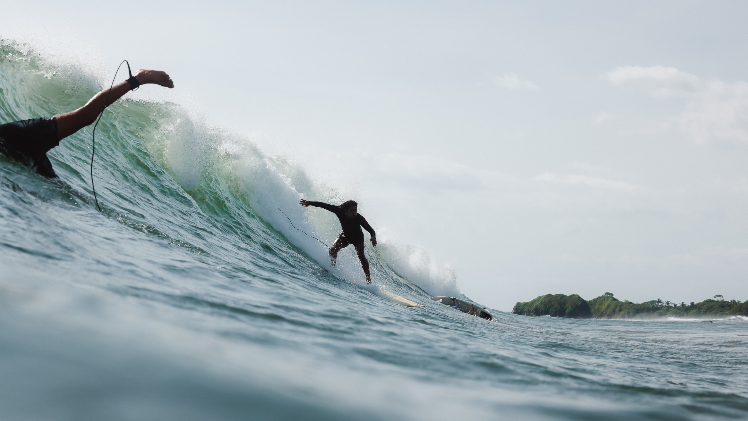 Coaches guiding groms on soft-tops at the shoreline